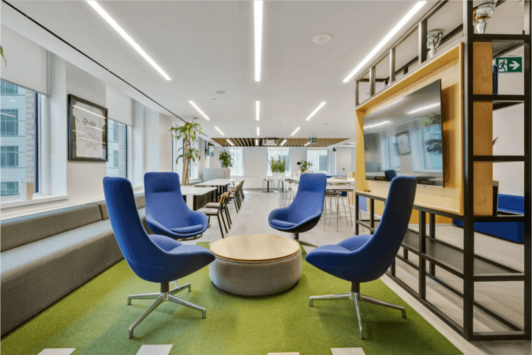 A modern lounge area in the open-concept Toronto office, with stylish blue chairs and a bright, spacious backdrop.