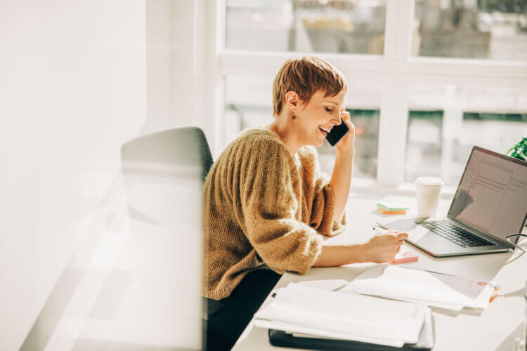 A photo of a female lawyer sitting at a desk referring someone to another lawyer using Clio Manage.