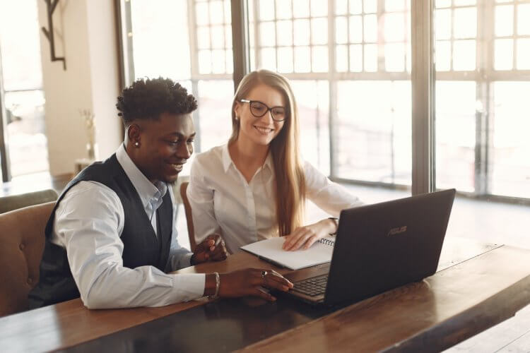 A photo of two people sitting behind a laptop picking out lawyer domain names