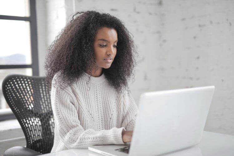 A photo of a legal professional sitting at a table on a laptop reviewing paralegal interview questions