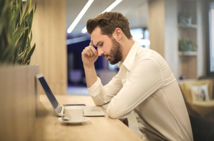 A lawyer sitting at a desk looking at a laptop stressed out