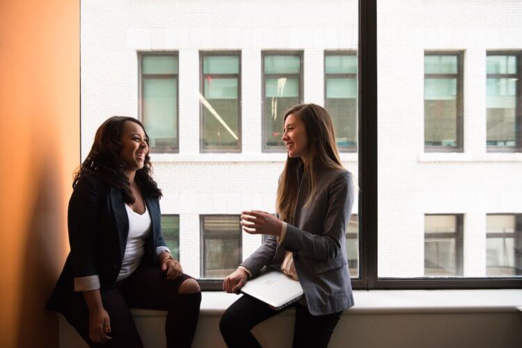 Two lawyers talking at window at their private practice.