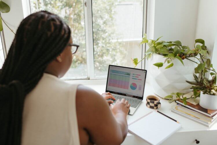 A lawyer sitting at a table on a laptop conducting financial planning work for her firm