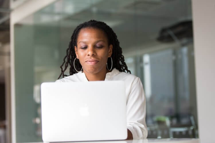 A lawyer sitting down typing on a laptop researching managed IT services for their firm