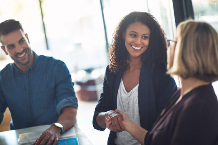 A photo of three people shaking hands and networking at a legal conference
